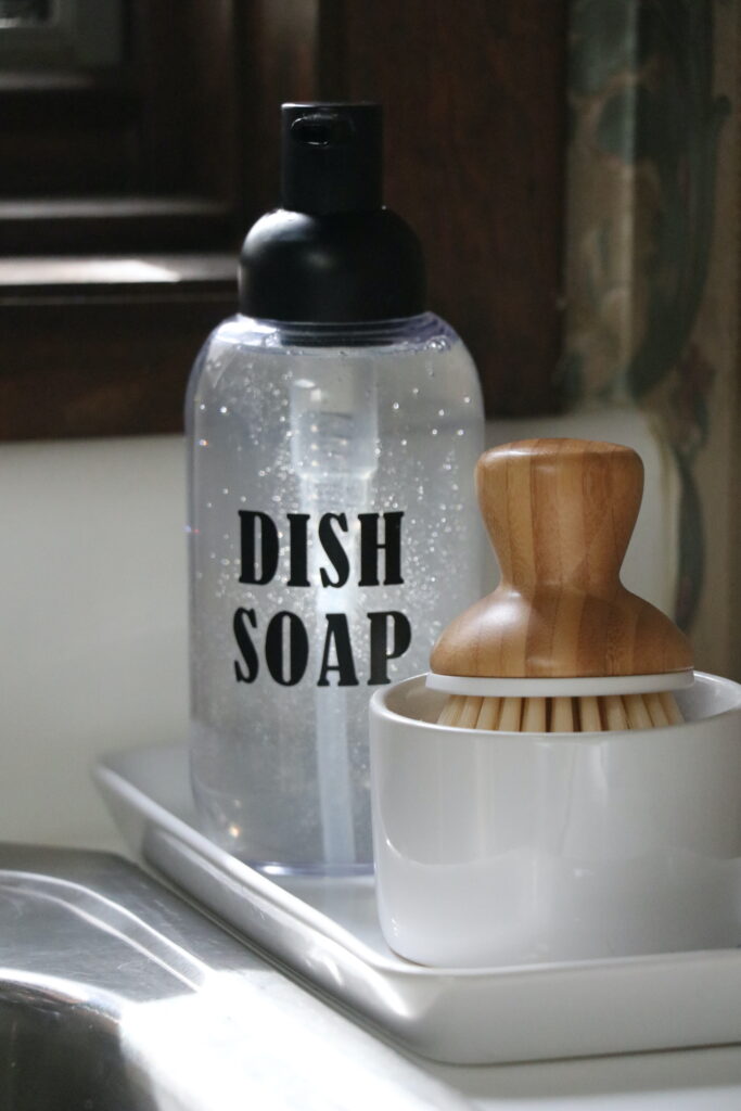 bottle labeled with dish soap and scrubber