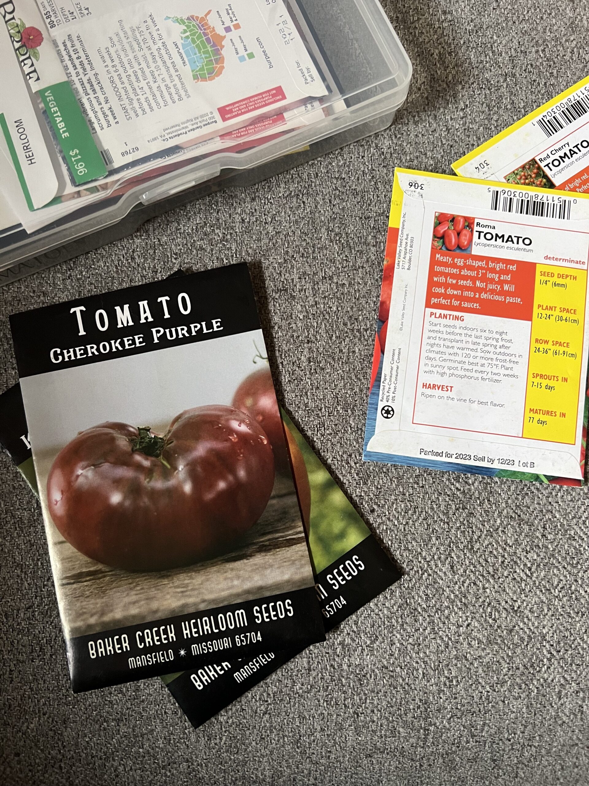 tomato seed packets next to case to store seeds